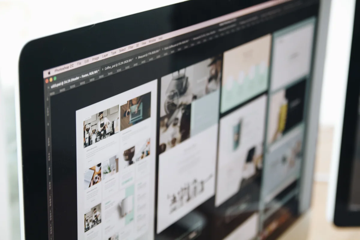 A laptop on a desk displaying a grid of portfolio work in review